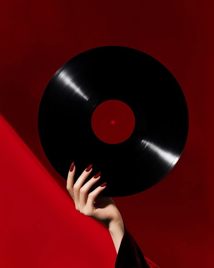 Mano con smalto rosso che regge un vinile su fondo rosso